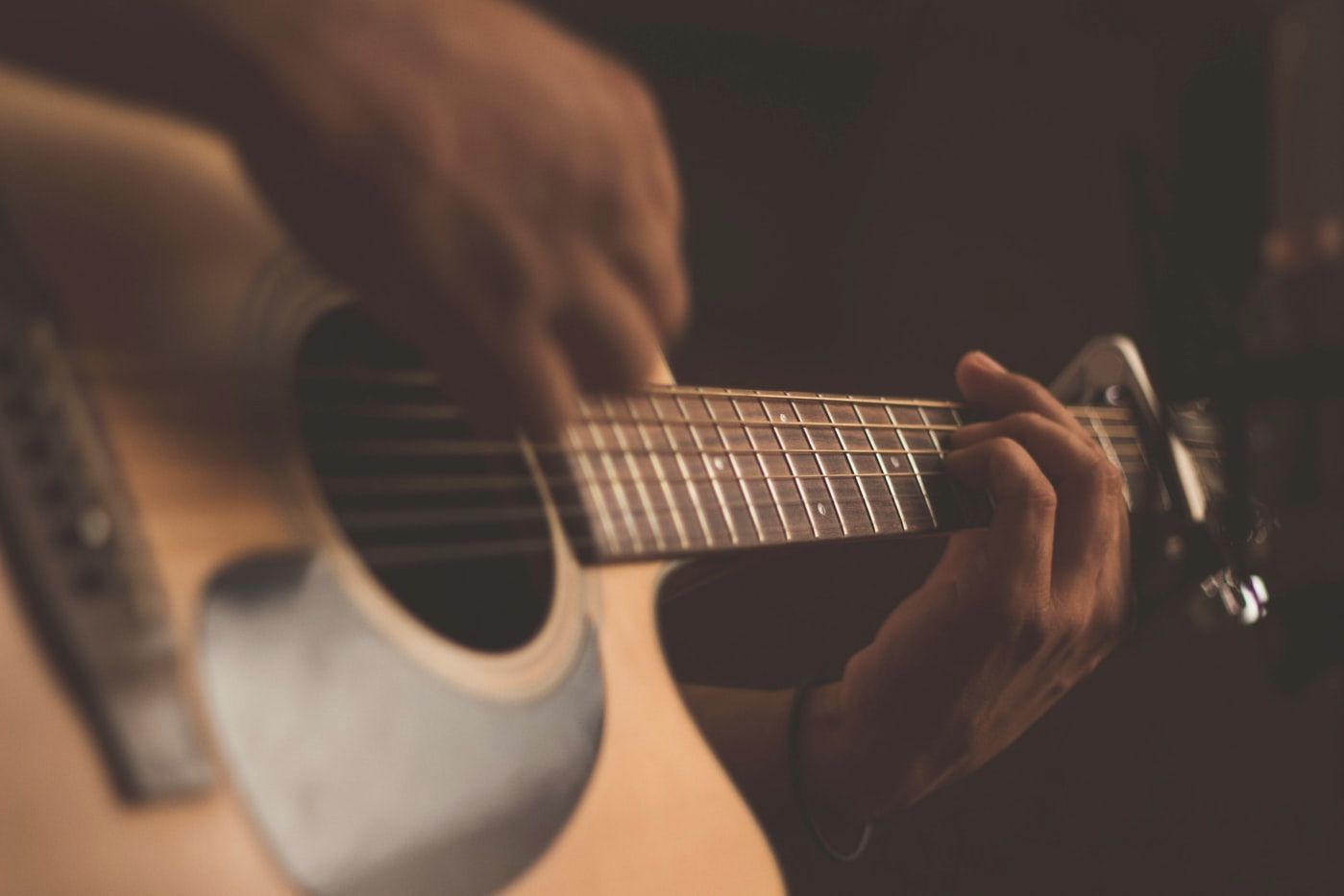 Hands working out a part on an acoustic guitar
